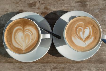 zwei Taschen Kaffee mit Latte Art Herzen